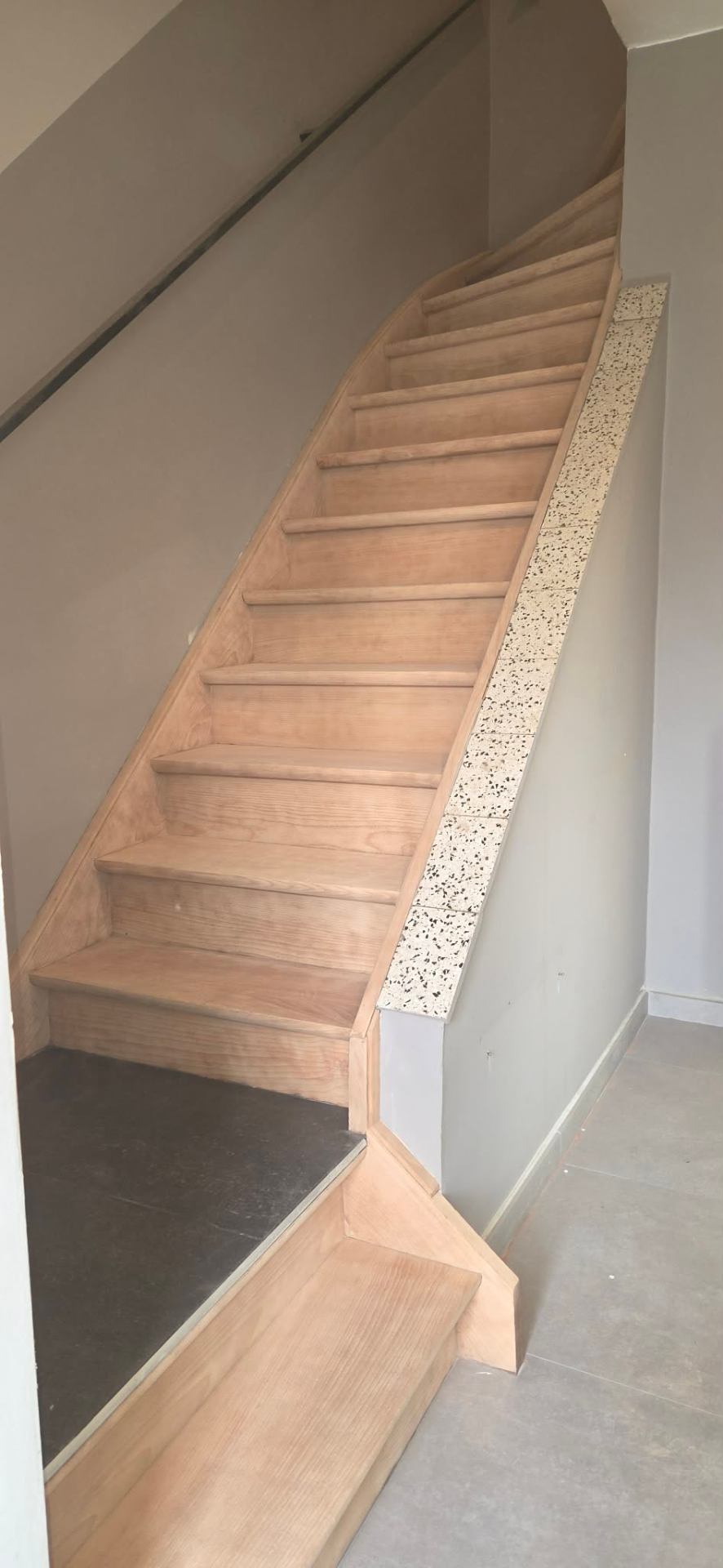 Le même escalier en bois remis à nu, après décapage par aérogommage